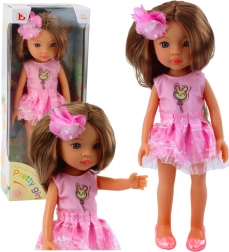 Poupée en robe rose avec de longs cheveux bruns et une barrette fleurie