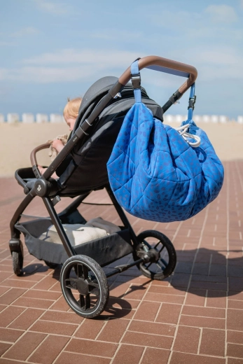 En voyage et sur la poussette grâce à la sangle d’épaule