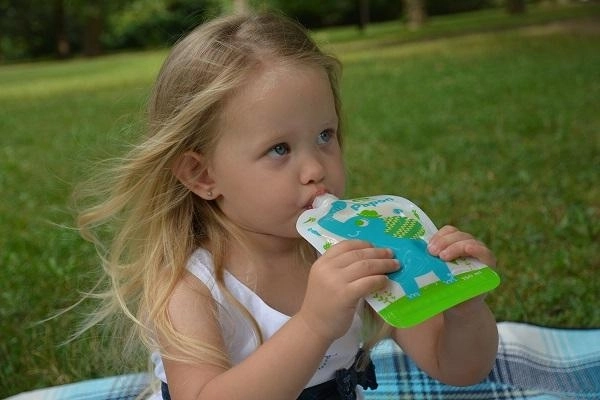 En voyage et dehors – l’enfant boit et mange tout seul