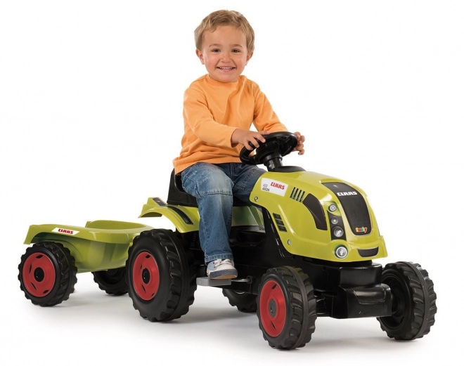 Tracteur à pédales CLAAS Arion 400 avec remorque verte