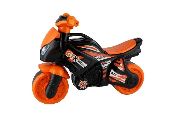 Moto trotteur orange-noir en plastique dans un sac 35x53x74cm 24m+
