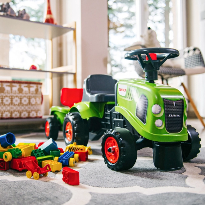 Tracteur pousseur Claas vert avec volant et remorque
