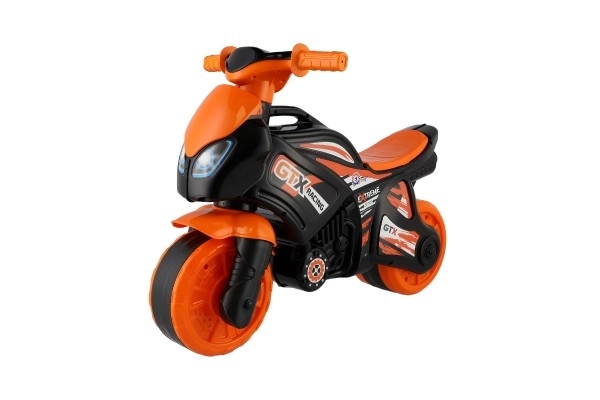 Moto trotteur orange-noir en plastique dans un sac 35x53x74cm 24m+