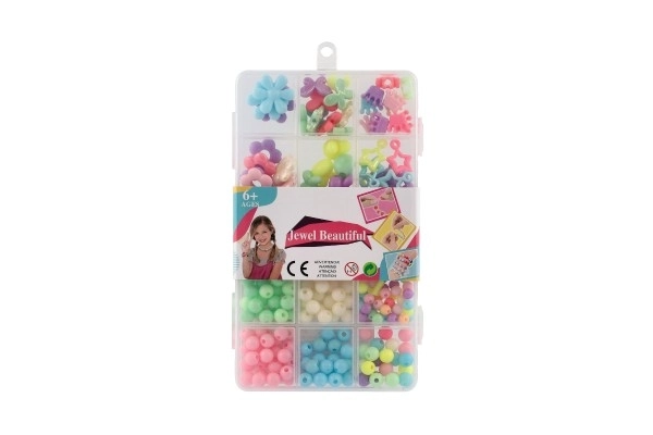 Perles en plastique colorées avec cordelette dans une boîte en plastique 10x17x2cm