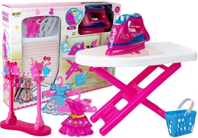 Set de repassage rose avec planche à repasser et cintres pour vêtements