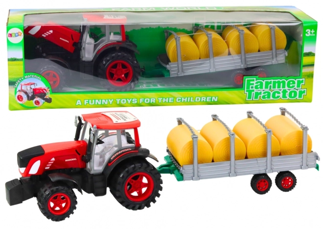 Grand tracteur avec remorque et balles de foin