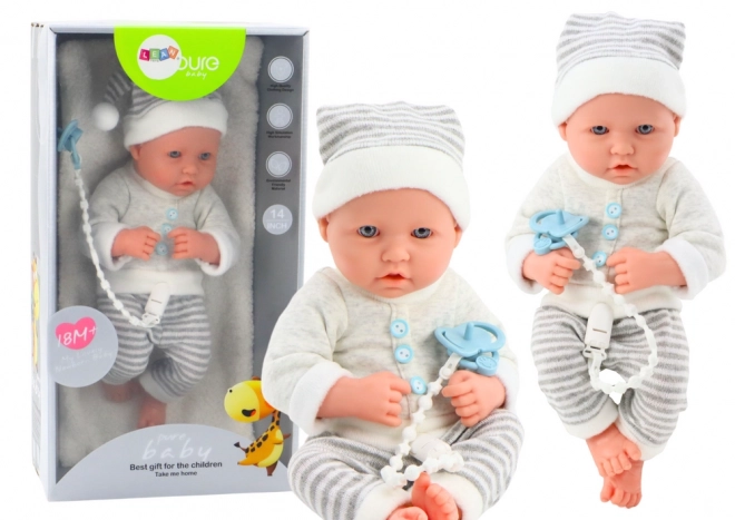 Poupée bébé réaliste en tenue blanc-gris avec bonnet et tétine