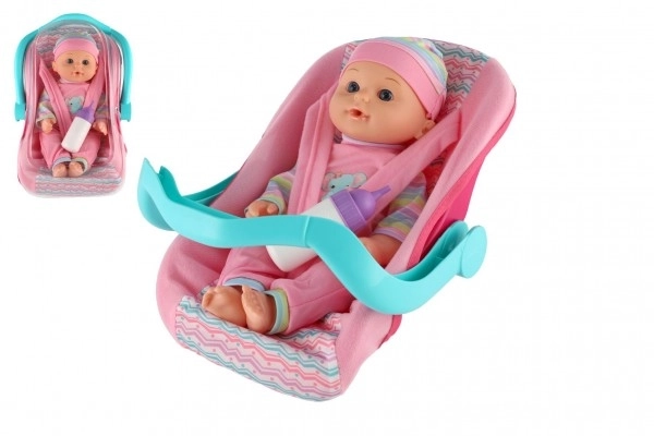 Poupée bébé 30cm en plastique dans un porte-bébé/siege auto avec biberon en blister