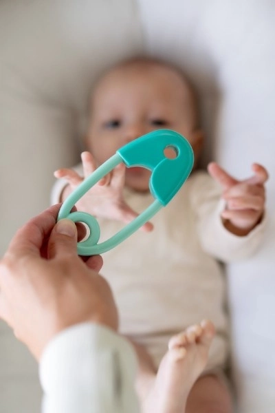 Hochet épingle plastique 12cm turquoise 12x19cm en sachet 0+