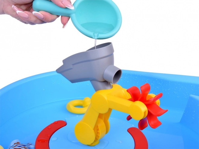 Table bleue d'eau avec roue à aubes et accessoires de pêche