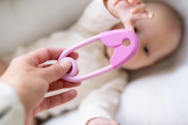 Hochet épingle plastique 12cm rose 12x19cm dans un sachet 0+