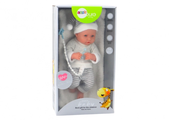 Poupée bébé réaliste en tenue blanc-gris avec bonnet et tétine