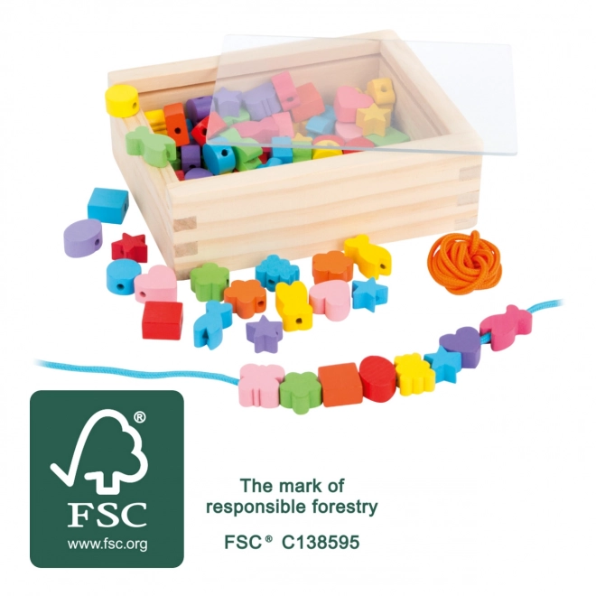 Petites perles en bois à enfiler formes dans une boîte
