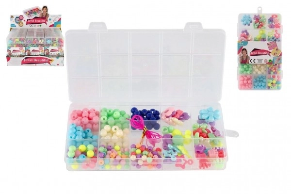 Perles en plastique colorées avec cordelette dans une boîte en plastique 10x17x2cm