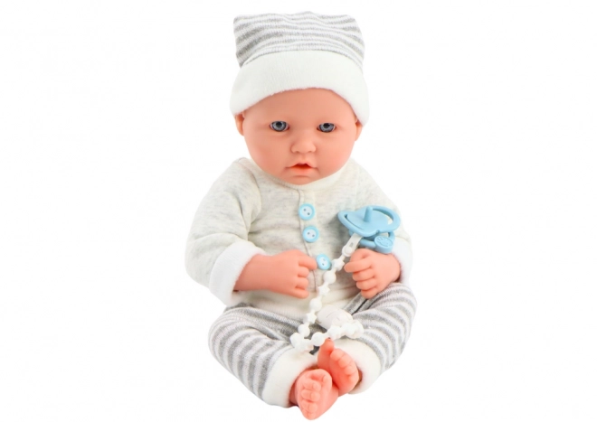 Poupée bébé réaliste en tenue blanc-gris avec bonnet et tétine
