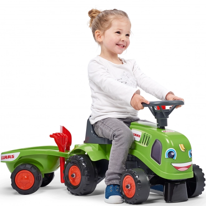 Tracteur pousseur Claas vert avec volant et remorque