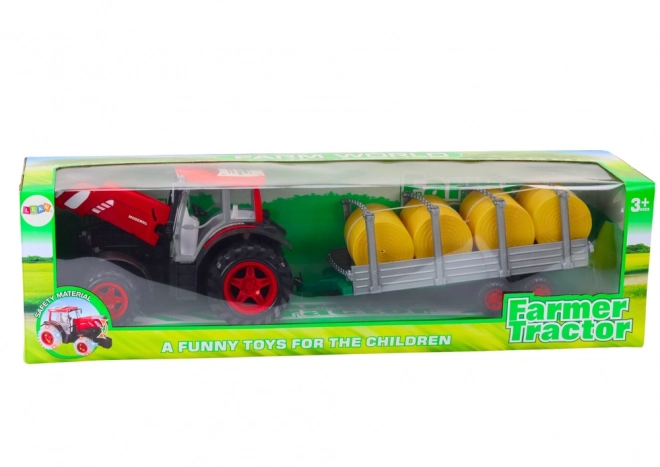 Grand tracteur avec remorque et balles de foin
