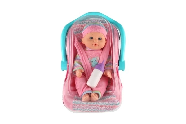 Poupée bébé 30cm en plastique dans un porte-bébé/siege auto avec biberon en blister