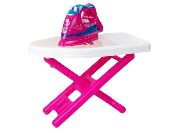 Set de repassage rose avec planche à repasser et cintres pour vêtements