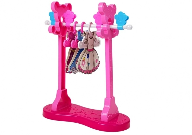 Set de repassage rose avec planche à repasser et cintres pour vêtements