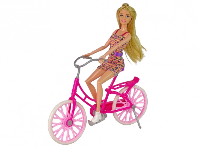 Poupée sur un vélo rose
